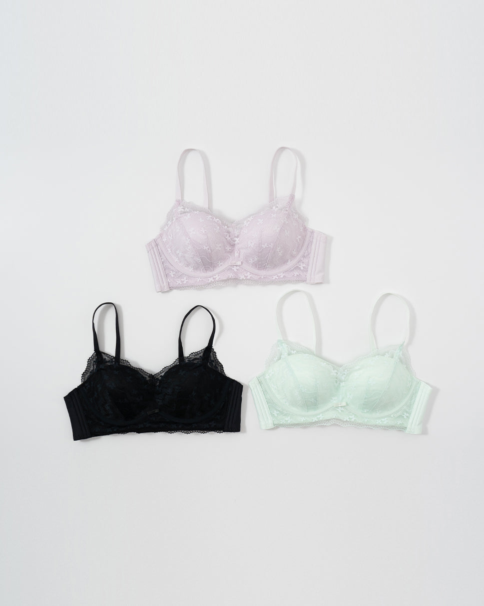 Three bras in black, purple, and green .