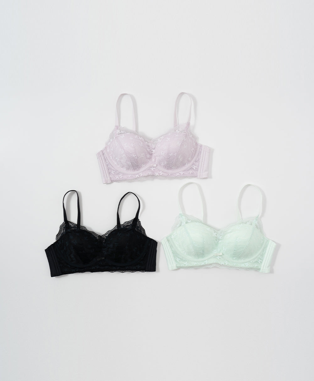 Three bras in black, purple, and green .